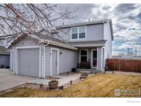 Charming two-story home with grey siding, a front porch, and a single car garage at 2218 E 109Th Dr, Northglenn, CO 80233