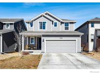 Charming two-story home with gray siding, a two-car garage, and a well-manicured front yard at 376 Country Rd, Berthoud, CO 80513