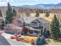 Stunning two-story home with mountain views, mature trees, and a charming front porch at 644 S Manorwood Ln, Louisville, CO 80027