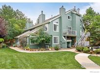 Inviting exterior featuring lush green lawn, charming garden and eye-catching architecture on a sunny day at 862 S Reed Ct # D, Lakewood, CO 80226