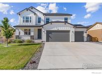 Charming two-story home with a well-maintained lawn and a spacious driveway leading to a two-car garage at 1013 Gabriella Ln, Berthoud, CO 80513