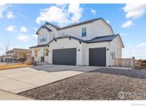 Beautiful two-story home showcasing a three car garage and modern farmhouse architectural design at 1013 Gabriella Ln, Berthoud, CO 80513