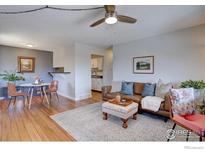 Inviting living room with wood floors, a leather couch, area rug and a view of the kitchen at 1105 Bacchus Dr # 8, Lafayette, CO 80026