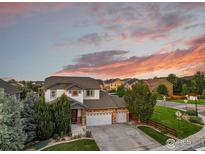 Stunning aerial view of a modern home featuring a three-car garage and well-manicured lawn at 12214 Roslyn St, Thornton, CO 80602