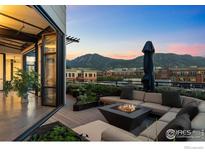 Inviting rooftop deck with sectional seating, fire pit, and mountain views at 1360 Walnut St # Ph 401, Boulder, CO 80302