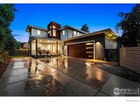 Beautiful modern home with a spacious driveway and manicured landscaping at dusk with ample outdoor lighting at 2050 Oak Ave, Boulder, CO 80304