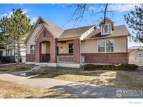 Charming, single-Gathering home featuring brick accents and a cozy covered porch at 2443 Winding Dr, Longmont, CO 80504