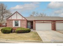 Charming brick home with attached garage and landscaped front yard at 2604 Elmhurst Cir, Longmont, CO 80503