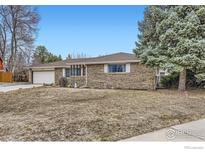 Charming brick ranch-style home with attached garage, mature tree, and a large front yard at 3045 Mcintosh Dr, Longmont, CO 80503