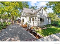 Charming two-story home featuring a welcoming front porch, landscaped yard, and gravel driveway at 3119 9Th St, Boulder, CO 80304