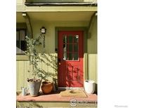 Inviting front door of a home with a red door, potted plants, and clear house numbers at 3209 Redstone Rd # 12B, Boulder, CO 80305