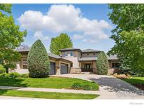 Beautiful home with a well-manicured lawn, mature trees, and a three-car garage at 4405 Fairway Ln, Broomfield, CO 80023