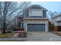 Charming two-story home features stone accents, gray siding, mature landscaping, and a two-car garage at 4866 Dakota Blvd, Boulder, CO 80304