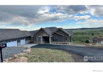 Beautiful single story home boasts stone accents, attached garage, and pristine landscaping at 5489 Country Club Dr, Larkspur, CO 80118