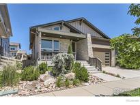 Charming single-Gathering home featuring stone accents, a covered porch, and a two-car garage at 5626 Four Leaf Dr, Longmont, CO 80503