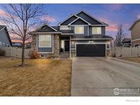 Charming two-story home featuring stone accents, a well-manicured lawn, and a two-car garage at 5786 Valley Vista Ave, Firestone, CO 80504