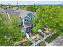 Charming blue two-story townhome with a well-manicured front yard and white picket fence at 588 Beauprez Ave, Lafayette, CO 80026