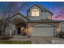 Charming two-story home featuring stone accents and a covered front porch with welcoming seating at 6657 Drew Ranch Ln, Boulder, CO 80301