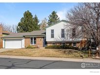 Charming home featuring brick and vinyl siding, a well-maintained lawn, and mature trees at 843 W Willow St, Louisville, CO 80027