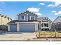 Charming two-story home featuring a three-car garage and blue siding at 908 Cinnamon Ln, Louisville, CO 80027