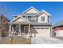 Charming two-story home featuring a covered porch, neutral siding, and a two-car garage at 1079 Larkspur Dr, Erie, CO 80516