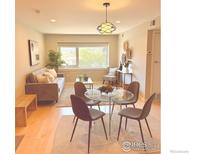 Bright living room featuring modern furniture, a decorative light fixture, and a large window with a lush green view at 1201 Balsam Ave # 203, Boulder, CO 80304