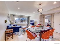 Cozy living space with blue sofa and orange dining set, offering mountain view from the window at 1201 Balsam Ave # 203, Boulder, CO 80304