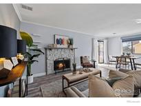 Inviting living room features a stone fireplace, wood floors, and abundant natural light at 12450 E Cornell Ave # 304, Aurora, CO 80014