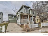 Inviting two-story home with a charming front porch and a well-maintained yard with white picket fence at 14031 Blue River Trl, Broomfield, CO 80023