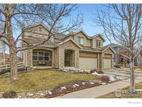 Charming two-story home featuring a stone facade, three-car garage, and well-manicured front yard at 14180 Whitney Cir, Broomfield, CO 80023