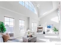 Bright, white living room with vaulted ceilings, large windows, and a cozy seating area at 1699 N Downing St # 409, Denver, CO 80218