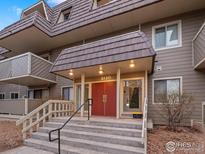 Attractive building entrance featuring red doors, covered entrance, and well maintained landscaping at 3120 Corona Trl # 301, Boulder, CO 80301