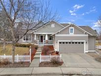 Charming home with neutral siding, two-car garage, and a welcoming front porch with a pathway and white picket fence at 462 Blue Lake Trl, Lafayette, CO 80026