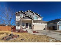 Charming two-story home with a two-car garage and a cozy front porch on a sunny day at 6834 Blue Spruce St, Frederick, CO 80530