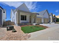 Charming two-story home with white siding, concrete driveway, and landscaped front yard at 729 Kubat Ln # A, Longmont, CO 80503