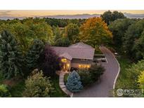 Stunning aerial view of a home surrounded by lush trees and mountain views in the background at 9539 N 89Th St, Longmont, CO 80503