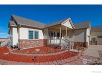 Charming one-story home with a welcoming porch, brick accents, and a well-maintained landscaped yard at 16498 S Essex S Rd, Platteville, CO 80651