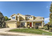 Charming two-story home with manicured lawn, red door, and solar panels against a beautiful blue sky at 201 High Lonesome Pt, Lafayette, CO 80026