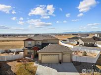 Attractive two-story home featuring a three car garage, a landscaped yard, and a white picket fence at 2100 Cadman St, Berthoud, CO 80513