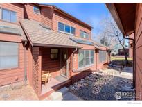 Charming townhouse featuring a cozy front porch and well-maintained landscaping with decorative rock and a brown exterior at 3104 Bell Dr, Boulder, CO 80301