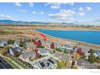 Aerial view showcases home's proximity to lake and neighborhood with colorful trees at 3916 Fowler Ln, Longmont, CO 80503