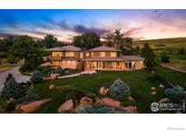 Stunning two-story home featuring lush landscaping and a well-maintained lawn at sunset at 1000 Spring Dr, Boulder, CO 80303