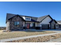 Beautiful single-Gathering home showcasing stone accents, a red front door, and a two-car garage at 1347 Burt Ave, Berthoud, CO 80513