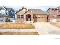 Charming single-Gathering home with a brick facade, attached garage, and well-maintained front yard at 2317 Winding Dr, Longmont, CO 80504