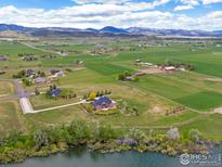 Stunning aerial view of the property, surrounded by lush greenery and distant mountains at 2366 Shoreside Dr, Berthoud, CO 80513