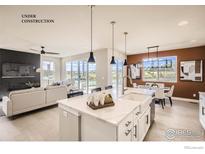 Bright, open kitchen features a center island, white cabinetry, and stainless steel appliances in an open-concept design at 2747 Crystal Springs, Longmont, CO 80503