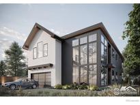 Modern home featuring a two-car garage and a stunning two-story glass window showcasing the staircase at 304 W Maple St, Louisville, CO 80027