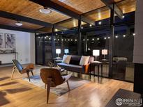 Stylish living room featuring wood ceilings, modern furniture, and large windows showcasing the night time outdoor space at 330 W Fair Ave, Littleton, CO 80120