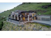 Stunning contemporary home on a hillside with stone accents, multiple balconies, and a three-car garage at 3645 Cholla Ct, Boulder, CO 80304