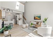 Bright living room features a vaulted ceiling, sleek flooring, and a modern design at 390 Owl Dr, Louisville, CO 80027